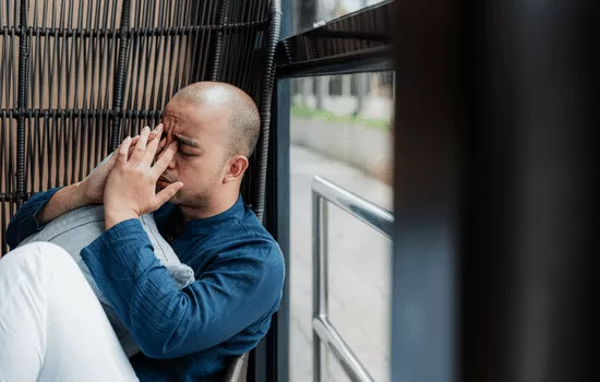 person with hands over face